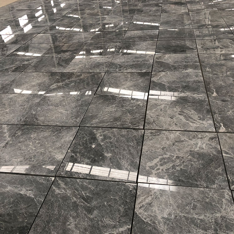How do environmental factors and moisture affect the performance of marble tiles in different areas of the home?
